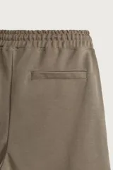 Bermuda estilo jogger de ajuste relajado, confeccionada en tejido interlock de algodón. Cuenta con cintura elástica ajustable con cordón, bolsillos frontales de vivo y diseño liso.