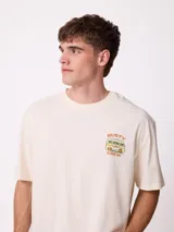 Remera negra de corte holgado con estampa gráfica en la espalda que representa un paisaje natural con árboles, una van y el texto 'Rusty' y 'Designed for disconnection'.