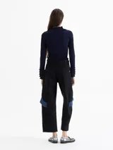 Pantalón de gabardina color marrón, de tiro alto y silueta estructurada. Cuenta con volados de denim azul aplicados sobre los bolsillos plaqué laterales y bolsillos plaqué traseros con remache dorado.