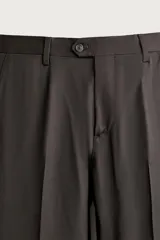 Pantalón de traje regular fit negro, confeccionado en lana italiana, con bolsillos laterales, bolsillos traseros de vivo con botón y cierre frontal de cremallera y botón.