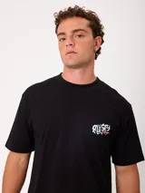 Remera negra de ajuste holgado con gran estampado gráfico en la espalda de temática tropical con una playa, palmeras y la inscripción "Welcome to Surfers Paradise".