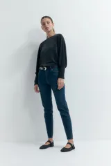 Jean slim de tiro alto color azul oscuro, con corte ajustado desde la cadera hasta el tobillo y largo hasta el tobillo.