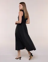 Vestido midi sin mangas de color verde militar, confeccionado con la parte superior en tejido de punto acanalado con cuello alto y falda acampanada de gran vuelo.