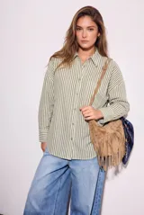 Camisa de corte oversize con estampado de rayas verticales, cuello clásico, cierre frontal con botones y bolsillo en el pecho. Presenta mangas largas con puños abotonados y un diseño fluido.