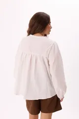 Blusa marrón con escote en V con lazo, mangas largas con elástico, detalle de bordados y puntillas.