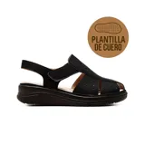 Sandalia casual Korium Confort modelo Jadiya, de color negro con detalles perforados en la capellada y tira ajustable con velcro en el talón. Posee suela gruesa y plantilla de cuero.