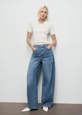 Pantalón de jean estilo balloon, de tiro medio y corte holgado, con diseño de cinco bolsillos, cierre de botón y cremallera.