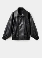 Parka de cuero ovino negro con diseño oversize, cuello embudo con cierre de cremallera, solapas amplias, cierre oculto de cremallera y botones, mangas largas con puños elásticos y bolsillos laterales.