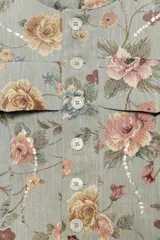 Blazer de jacquard de algodón con estampado floreado, cuello subido, manga larga y cierre frontal con botones. Presenta bolsillos de plastrón en el delantero, detalle de aplicación de lentejuelas, forro interior a tono y bajo asimétrico.