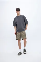 Remera de algodón con calce oversize y textura suave. Presenta un diseño de cuello redondo, mangas cortas con bordado detallado en una de ellas y un acabado de tela lavada.