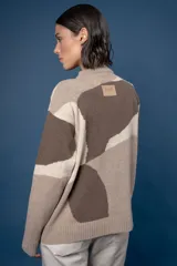 Buzo de punto con diseño abstracto que simula un paisaje, cuello redondo y mangas largas. Confeccionado en lana, presenta una combinación de colores en tonos beige, celeste y gris.