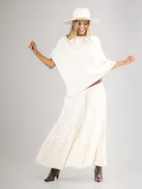 Poncho de corte holgado y diseño minimalista, confeccionado en tejido liviano de color beige, con cuello redondo y caída fluida.