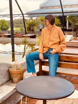 Cárdigan tejido color tostado, de lana, con cuello redondo y abotonadura frontal.