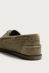 Zapato náutico de hombre confeccionado en piel con acabado en serraje, color marrón claro, con detalles de cordones y ojales metálicos.