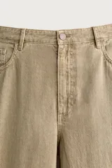 Pantalón relaxed fit de color beige, confeccionado en tejido con mezcla de algodón y lino, con diseño de cinco bolsillos, efecto lavado y cierre frontal con cremallera y botón.