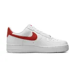 Championes Nike Air Force 1 de corte bajo, color blanco con detalles en rojo en el logo lateral y en el talón. Diseño clásico con perforaciones en la puntera y suela de goma.