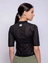 Top blanco de cuello alto y manga tres cuartos, con diseño de transparencias.