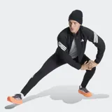Campera deportiva Adidas de corte clásico, color negro con detalles en blanco. Presenta cierre frontal, cuello alto, bolsillos con cremallera y las icónicas tres bandas de la marca en las mangas. Incluye inserciones de malla para mayor ventilación y dobladillo con cordón elástico ajustable.