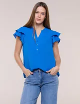 Blusa de gasa azul, con escote en V y abotonadura frontal parcial. Cuenta con mangas cortas decoradas con doble capa de volados.