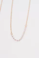 Set de cuatro collares de cadena fina en color dorado. Incluye una cadena simple, una con dije de corazón, una con detalles de perlas pequeñas y una con dijes colgantes en forma de cruz.