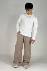 Pantalón jean color beige, corte holgado y estilo cargo.