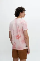 Remera manga corta color rosa con efecto tie-dye y estampa con texto y dibujo en el frente.