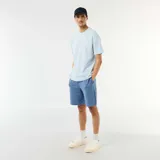 Bermuda de felpa ligera color azul, corte estándar y bolsillos laterales, ideal para un look casual y cómodo.