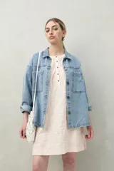 Vestido corto negro con bordado floral blanco, escote redondo con abotonadura frontal y mangas 3/4 abullonadas con pliegues en los hombros.