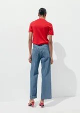 Jeans wide leg de tiro alto en tejido denim azul, con bolsillos de parche delanteros, trabillas para cinto y cierre frontal con cremallera y botón.