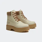 Botas Timberland modelo Stone Street de caña media, color beige con suela de plataforma dentada en color tostado. Presentan cuello acolchado en tono marrón, cierre de cordones con ojales metálicos dorados y logo de la marca grabado en el lateral.