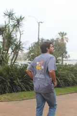 Remera gris de corte recto confeccionada en algodón peinado. Presenta estampa en la espalda con diseño floral y la frase "Más flores, menos drama".