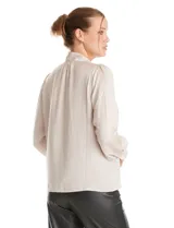 Blusa negra de acabado satinado con cuello alto fruncido, detalle de lazo para anudar y cierre lateral con botones. Presenta mangas largas estilo balloon con puños ajustados.