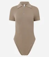 Body color beige de poliamida, con diseño seamless acanalado, cuello polo, manga corta y cierre de cremallera delantera.