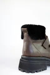 Bota corta de cuero marrón con puntera de gamuza, cuello de piel sintética negra, cierre con velcro y suela track negra.