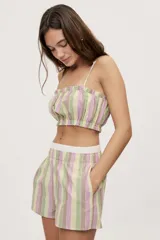 Short a rayas verticales en tonos verde, lila, amarillo y marrón, con tiro medio, cintura elástica en contraste y bolsillos laterales, de calce relajado.