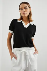 Remera negra de punto con cuello polo y ribetes blancos en cuello y mangas.