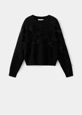 Sweater de punto grueso color negro, con cuello redondo, diseño recto y manga larga, adornado con aplicaciones de plumas de avestruz en el pecho y las mangas.