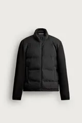 Campera puffer negra con cuerpo acolchado y mangas de tejido liso elastizado, cuello subido y cierre frontal de cremallera.