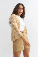 Cardigan abierto de tejido de punto fino en color beige, con mangas tres cuartos y terminaciones acanaladas en puños y frente.