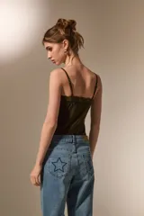 Body de breteles finos color blanco, con escote en V y detalle de encaje en el borde superior. Confeccionado en poliéster, presenta un diseño ajustado al cuerpo con cierre de broches en la parte inferior.