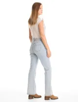 Jean de tiro alto con corte bootcut, confeccionado en denim de lavado claro. Presenta cierre frontal con botón, bolsillos funcionales y detalle de pespuntes verticales con aplicación de tachas a lo largo de las piernas.