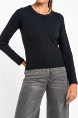 Remera negra de manga larga, con cuello redondo y tejido acanalado, de corte ajustado al cuerpo.