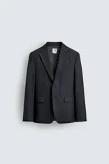 Blazer de corte regular confeccionada en lana de origen italiano, con diseño a cuadros sutiles. Presenta cuello con solapas de muesca, cierre frontal de un botón, bolsillos laterales con solapa y bolsillo en el pecho. Cuenta con aberturas en la espalda y forro interior.