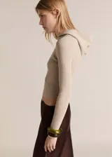 Jersey de punto canalé con diseño crop y ajuste slim fit. Presenta cuello alto con capucha integrada y manga larga.
