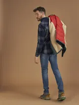 Campera de abrigo azul marino con capucha, cierre frontal con botones y cremallera, múltiples bolsillos y forro interior naranja.