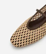 Zapatilla tipo bailarina con capellada tejida con efecto rafia color beige, punta redonda, tira fina marrón con hebilla y suela marrón.