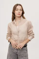 Camisa de manga larga con diseño de rayas verticales en tonos celestes, blancos y marrones, confeccionada en tejido semitransparente con cuello camisero y cierre frontal de botones.