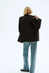 Blazer de sarga con solapas de pico, diseño de frente abierto y bolsillos delanteros con solapa. Presenta mangas con forro a rayas diseñado para ser remangado.