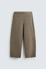 Pantalón de corte balloon fit en color gris, confeccionado en tejido con viscosa. Presenta pliegues frontales, cintura con cinturón integrado a contraste, bolsillos laterales y bolsillos traseros de vivo.