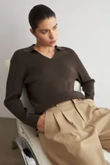 Sweater de punto acanalado color marrón, con cuello polo y escote en V, de manga larga y calce holgado.